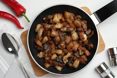 Photo of Tasty fried cracklings on white wooden table, flat lay. Cooked pork lard