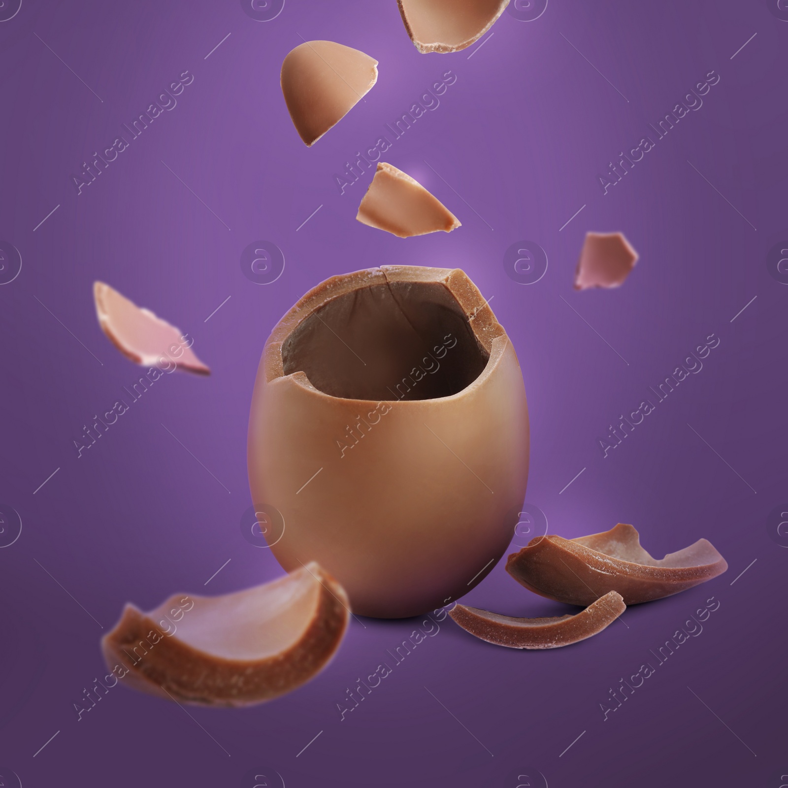 Image of Exploded milk chocolate egg on purple background