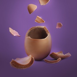 Image of Exploded milk chocolate egg on purple background