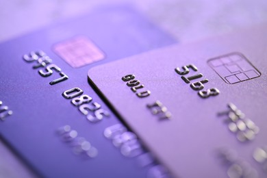 Photo of Plastic credit cards on table, macro view. Color toned