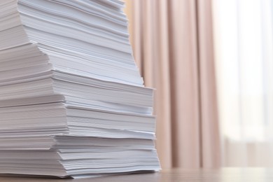 Stack of paper sheets on wooden table indoors, closeup. Space for text