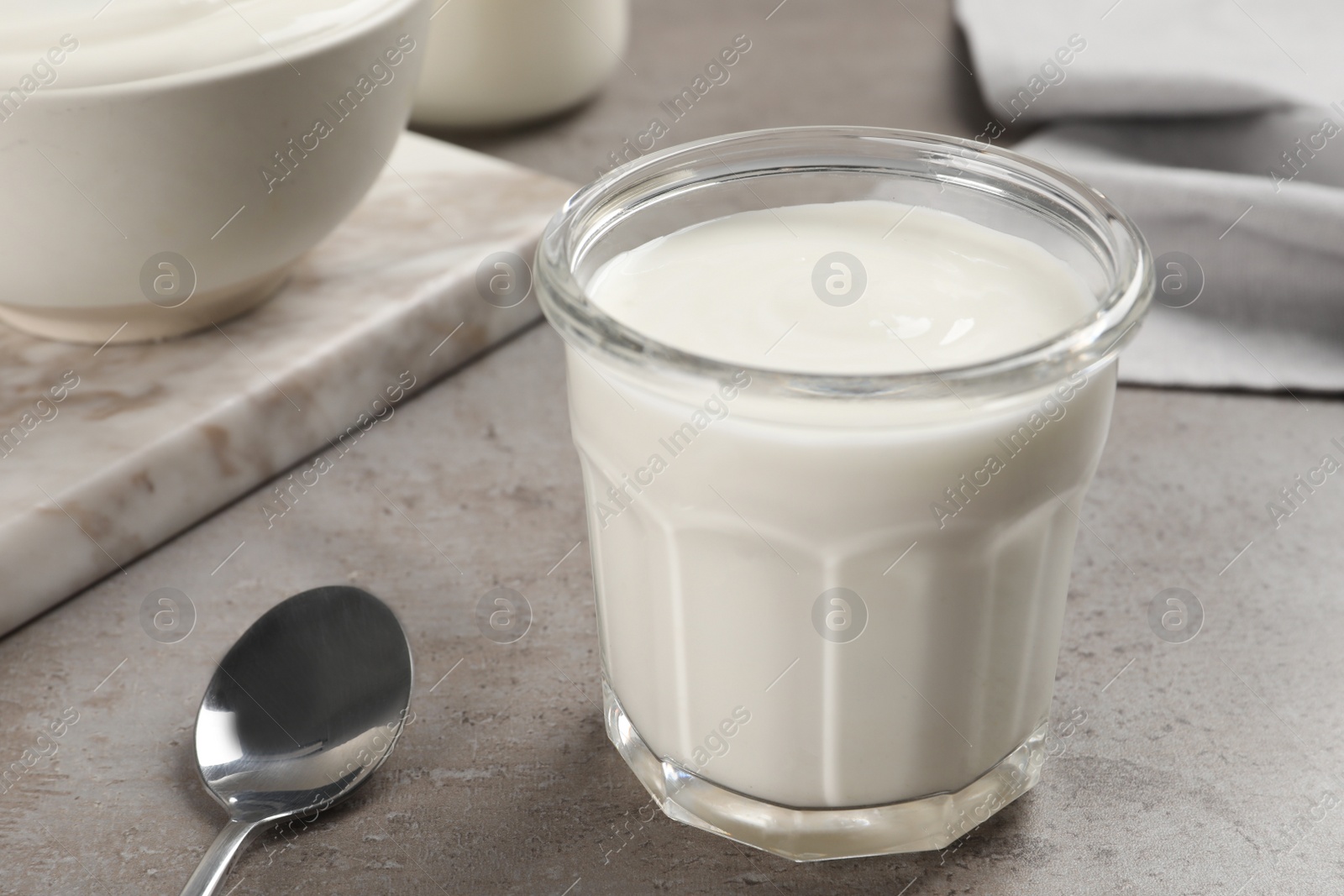 Photo of Jar with delicious organic yogurt on grey table, closeup