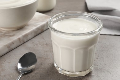 Jar with delicious organic yogurt on grey table, closeup