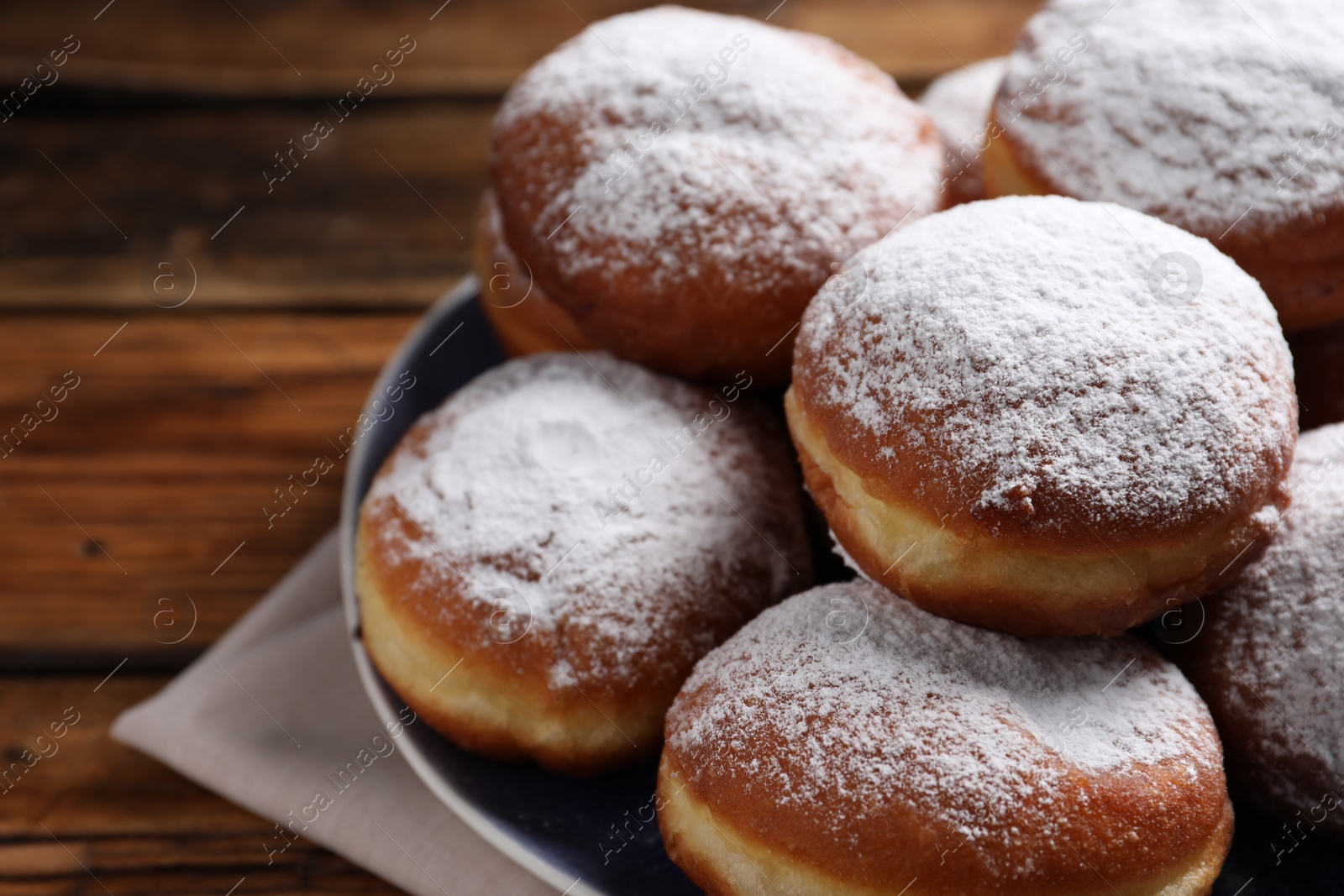 Photo of Delicious sweet buns with powdered sugar on table, closeup