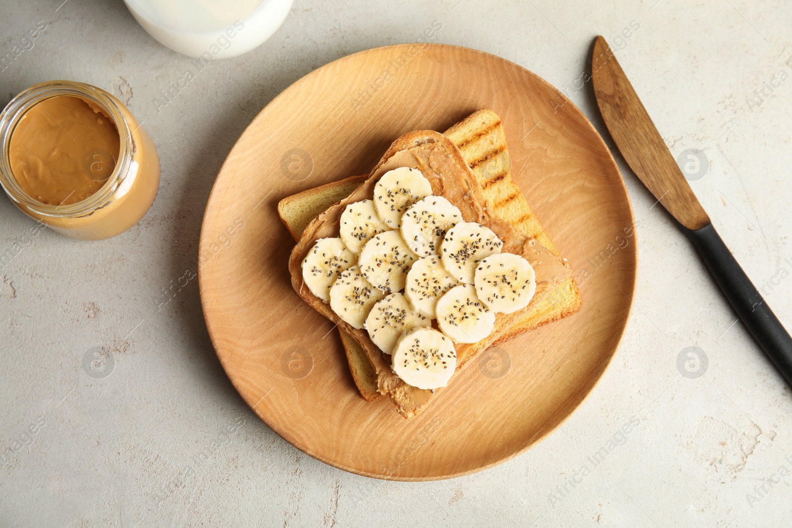 Photo of Tasty toasts with banana, peanut butter and chia seeds served on table, top view