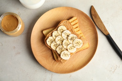 Photo of Tasty toasts with banana, peanut butter and chia seeds served on table, top view