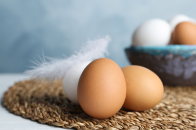 Photo of Fresh raw chicken eggs on wicker mat