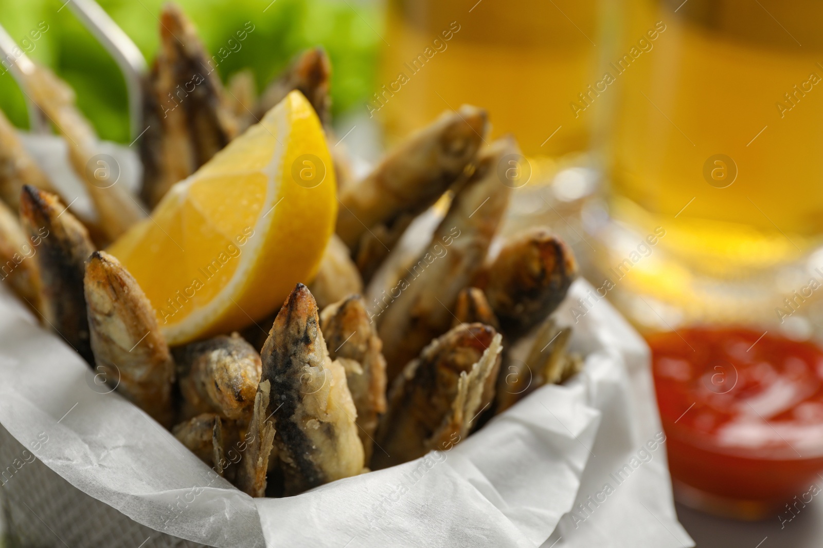 Photo of Delicious fried anchovies, lemon and sauce, closeup view