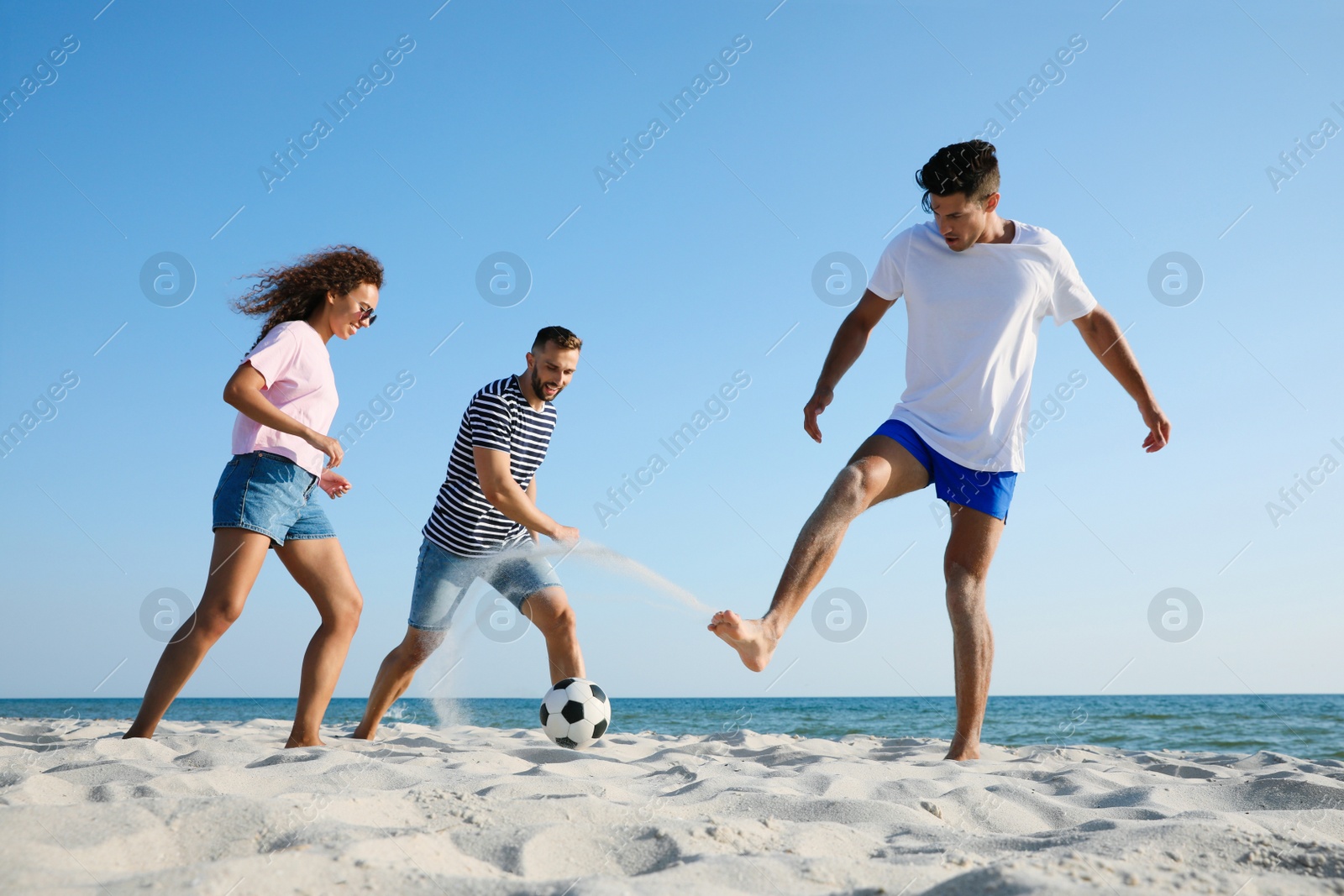 Photo of Group of friends playing football on beach