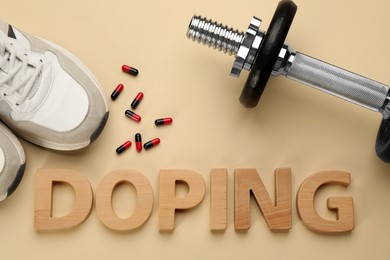 Photo of Word Doping, drugs, dumbbell and sport shoes on beige background, flat lay