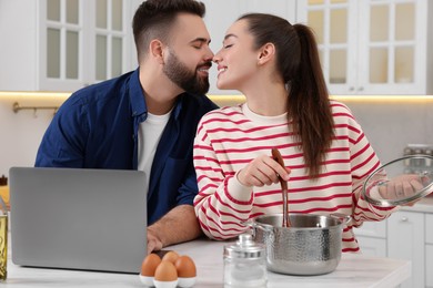 Photo of Happy lovely couple enjoying time together while cooking in kitchen