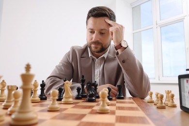 Photo of Man playing chess during tournament at table indoors