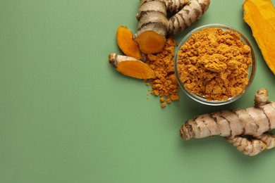 Photo of Aromatic turmeric powder and raw roots on green background, flat lay. Space for text