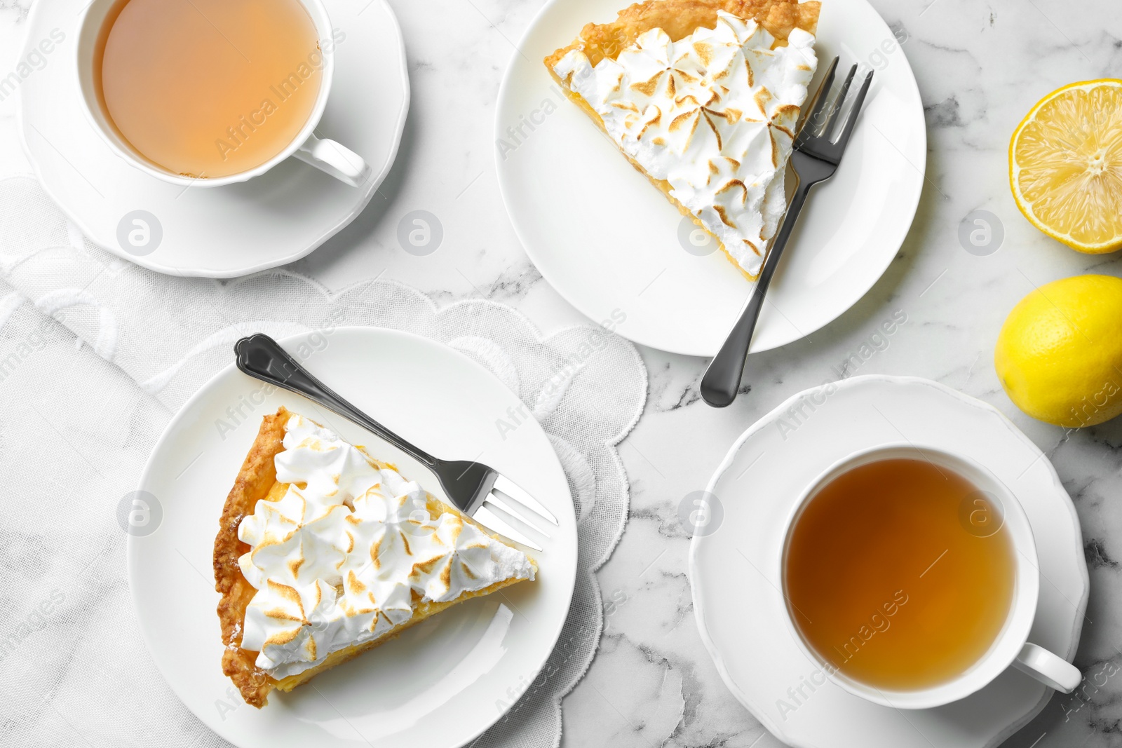 Photo of Delicious lemon meringue pie served on white marble table, flat lay