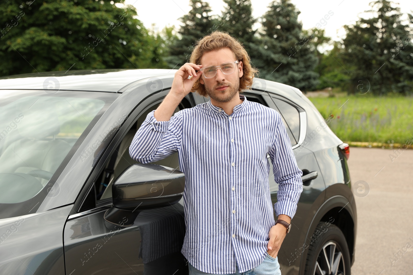 Photo of Attractive young man near luxury car outdoors