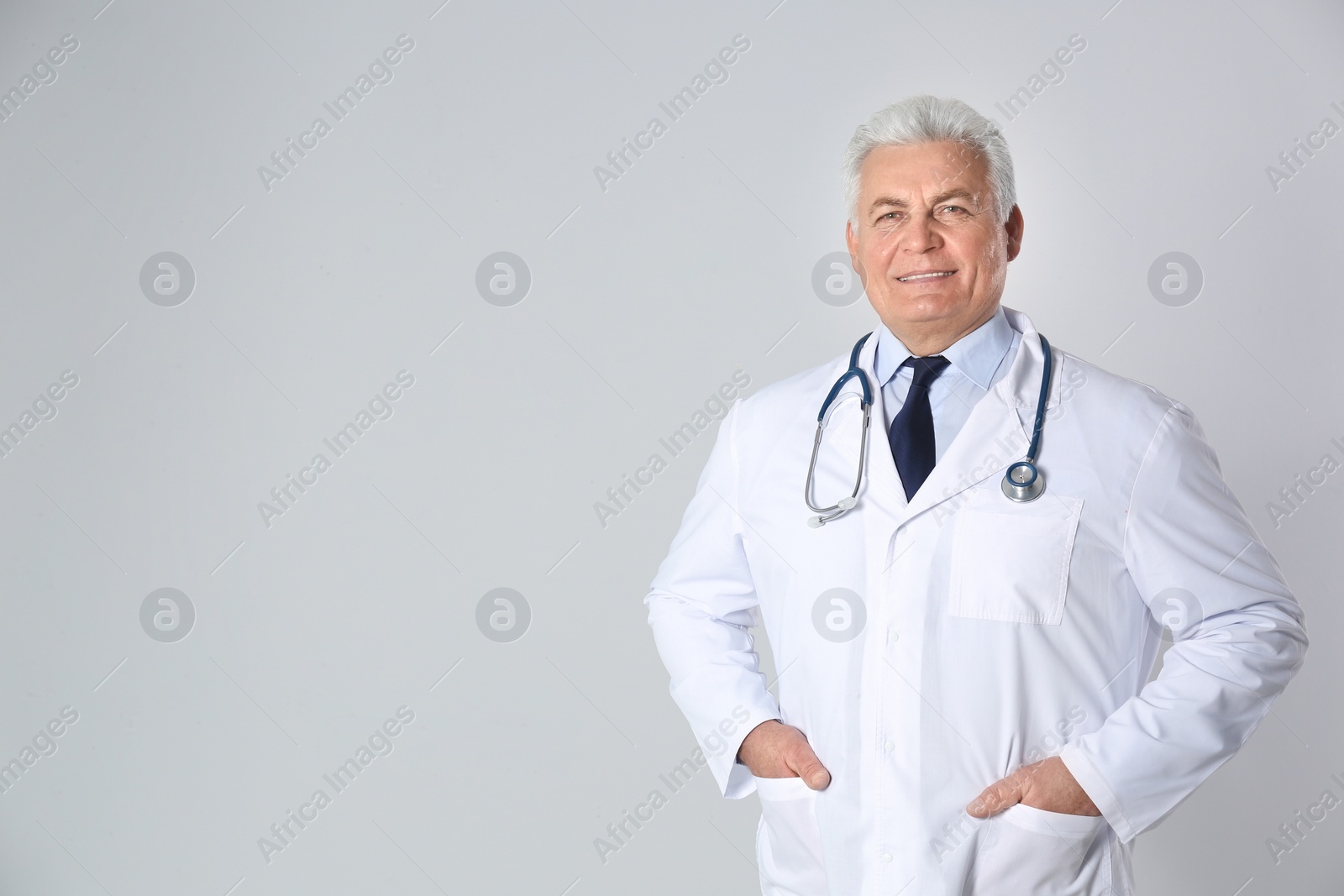 Photo of Portrait of senior doctor against light background