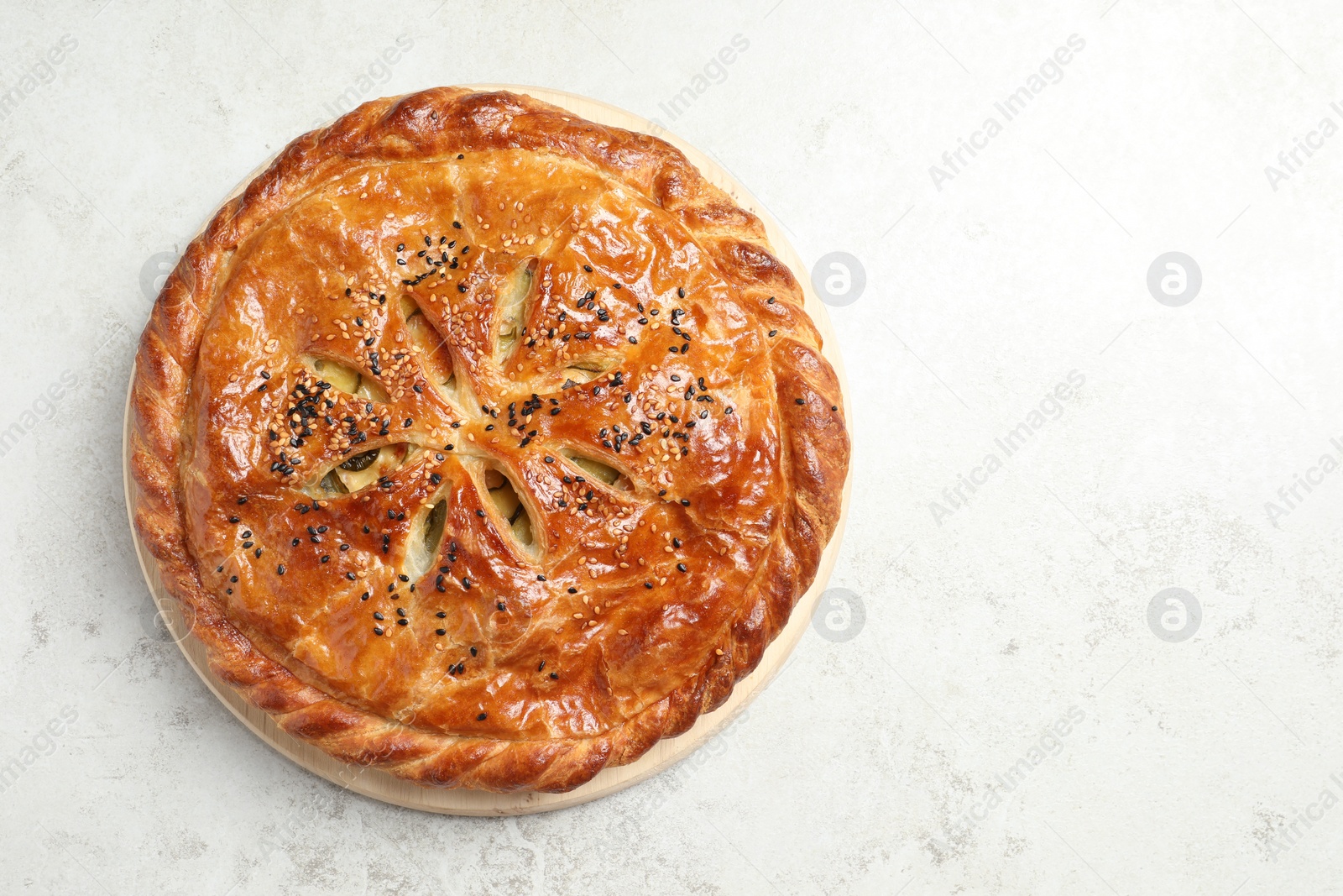 Photo of Tasty homemade pie with filling on light table, top view. Space for text