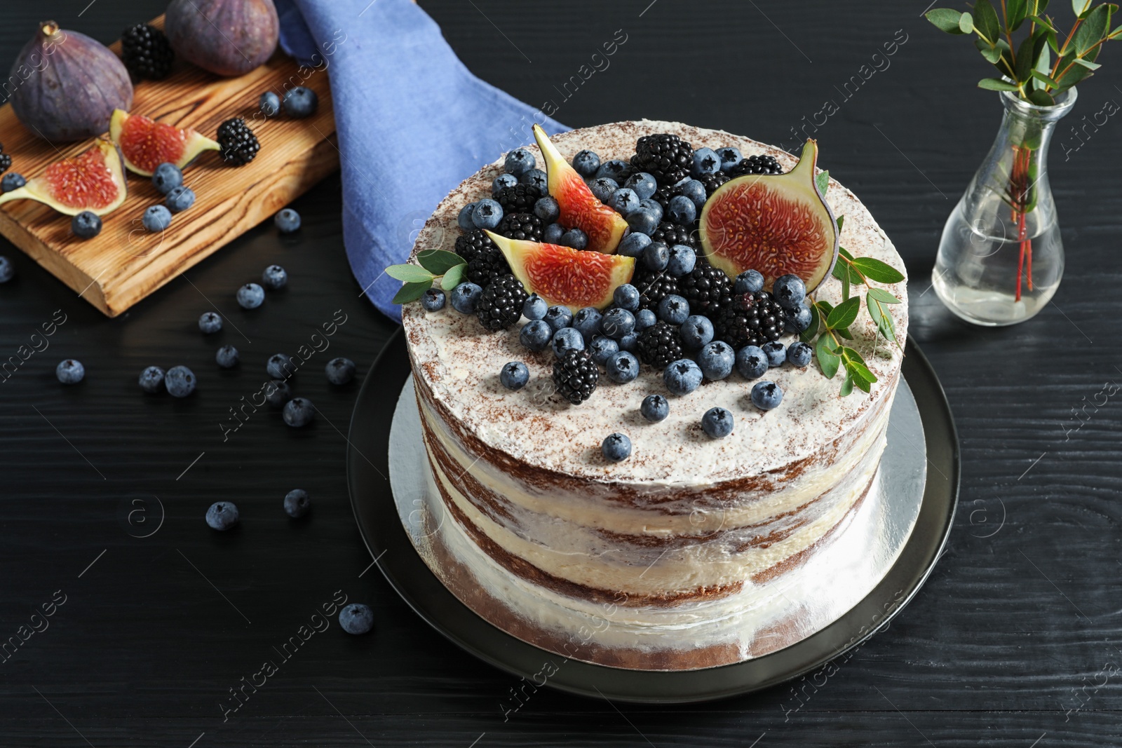 Photo of Delicious homemade cake with fresh berries served on dark wooden table