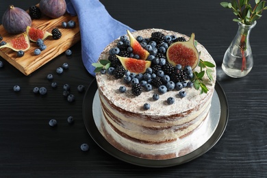 Delicious homemade cake with fresh berries served on dark wooden table