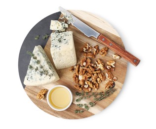 Photo of Serving board with tasty blue cheese, thyme, honey and walnuts isolated on white, top view