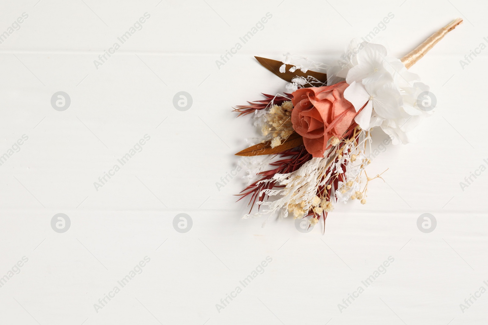 Photo of Beautiful boutonniere on white background, top view. Space for text