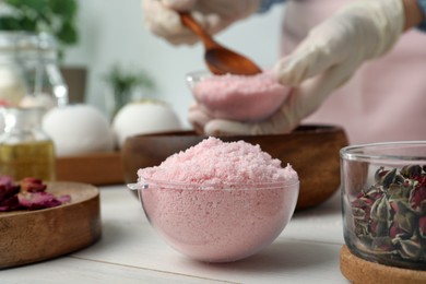 Photo of Pink bath bomb mixture in mold and blurred view of woman on background