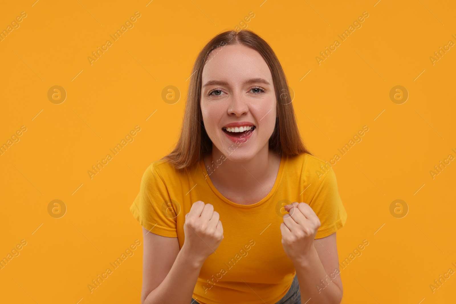 Photo of Emotional sports fan celebrating on yellow background