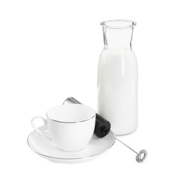 Photo of Milk frother wand, cup and glass carafe isolated on white