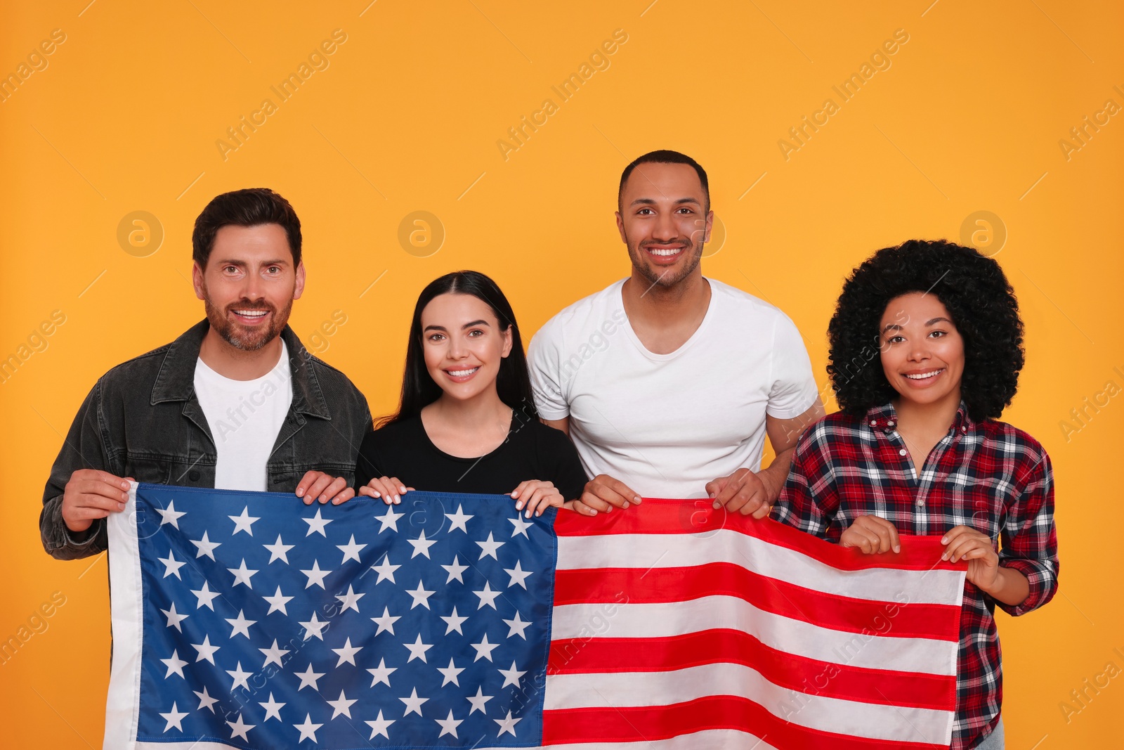 Photo of 4th of July - Independence Day of USA. Happy friends with American flag on yellow background