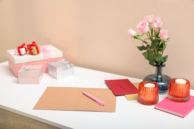 Greeting card, flowers and candles on white table indoors