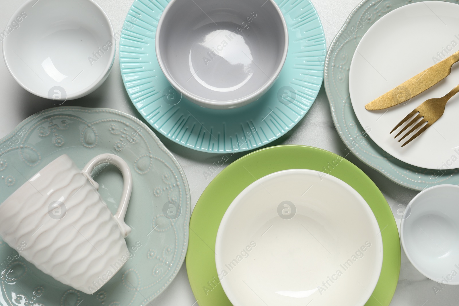 Photo of Beautiful ceramic dishware, cup and cutlery on white table, flat lay