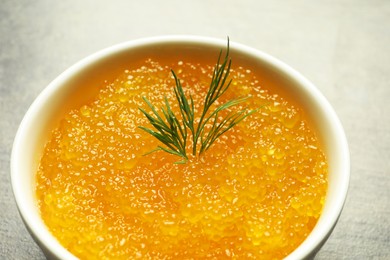Photo of Fresh pike caviar and dill in bowl on grey table, closeup