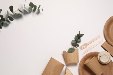 Photo of Eco friendly food packaging. Paper containers, tableware and eucalyptus branches on white background, flat lay. Space for text