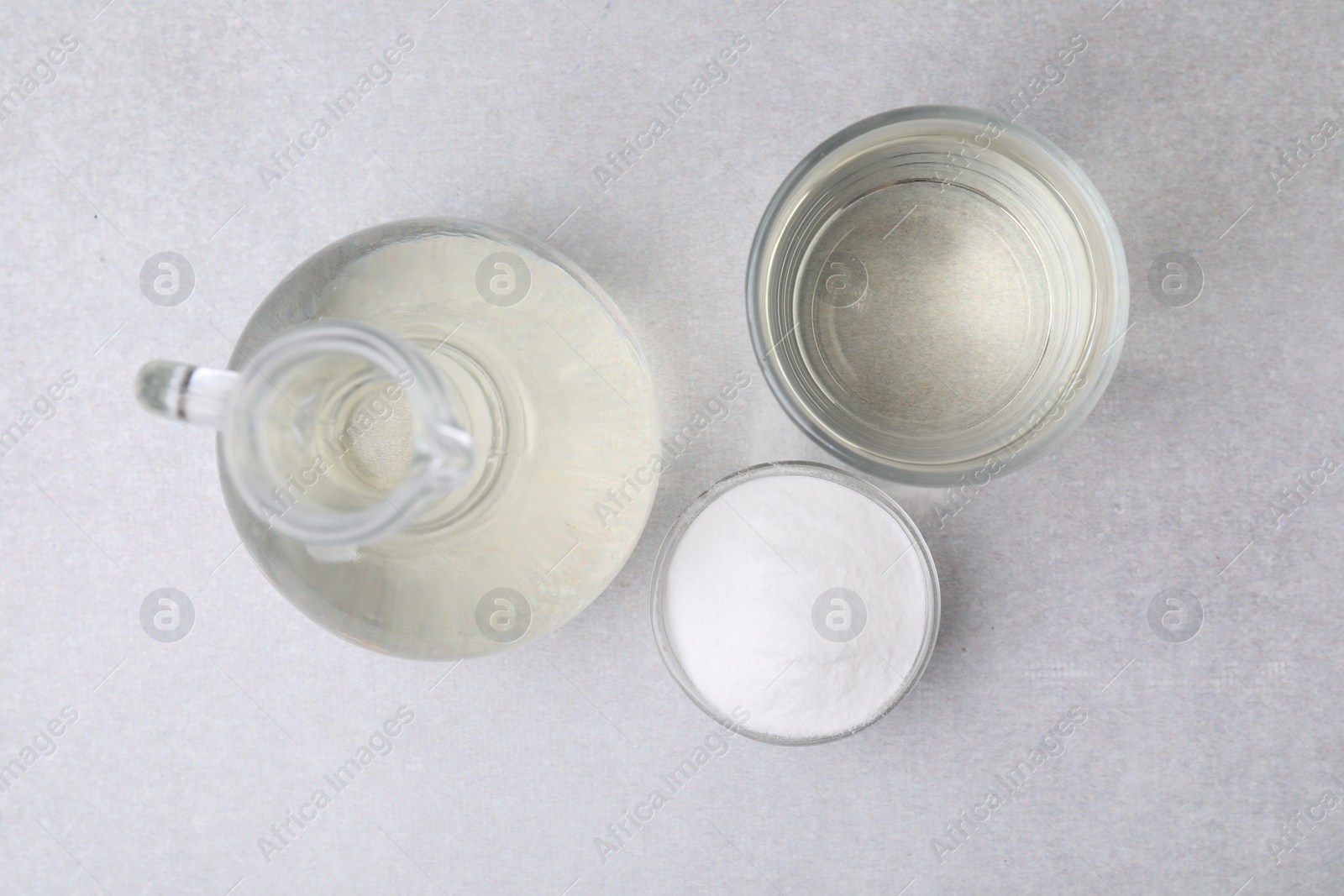 Photo of Vinegar and baking soda on light table, flat lay