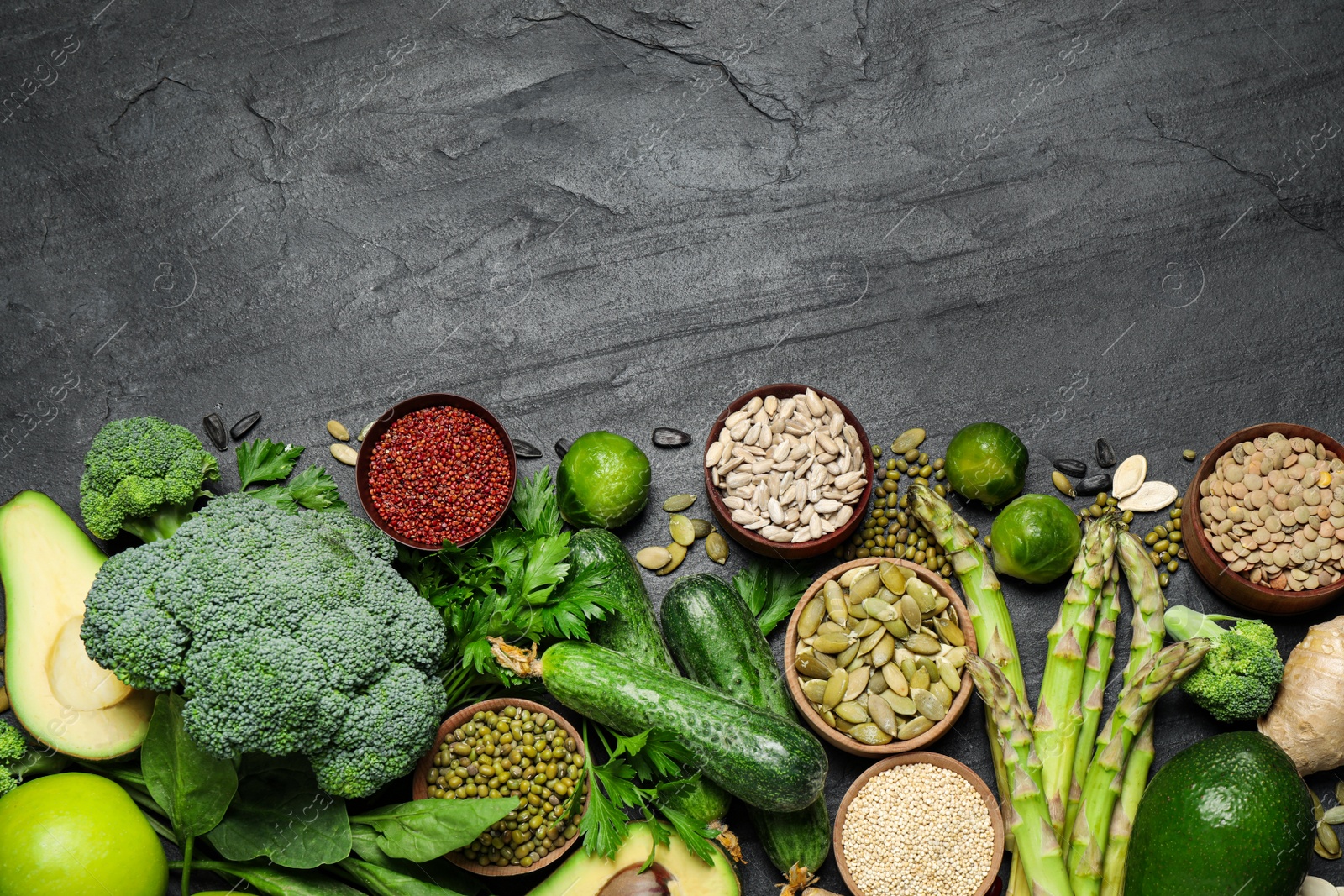 Photo of Different vegetables, seeds and fruits on black table. Healthy diet