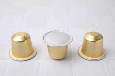 Coffee capsules on white tiled table, closeup