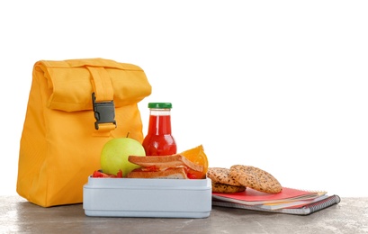 Lunch box with appetizing food and bag on table against white background