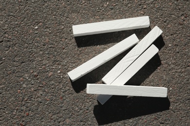 Photo of White chalk sticks on asphalt, top view