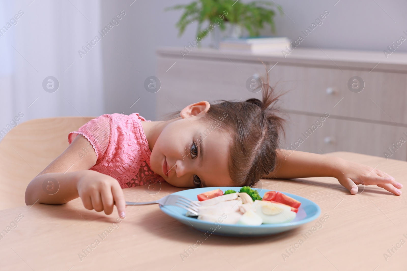 Photo of Cute little girl refusing to eat her breakfast at home