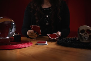 Soothsayer predicting future with cards at table indoors, closeup
