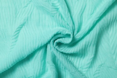 Texture of turquoise crumpled fabric as background, top view