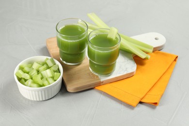 Photo of Celery juice and fresh vegetables on light gray table