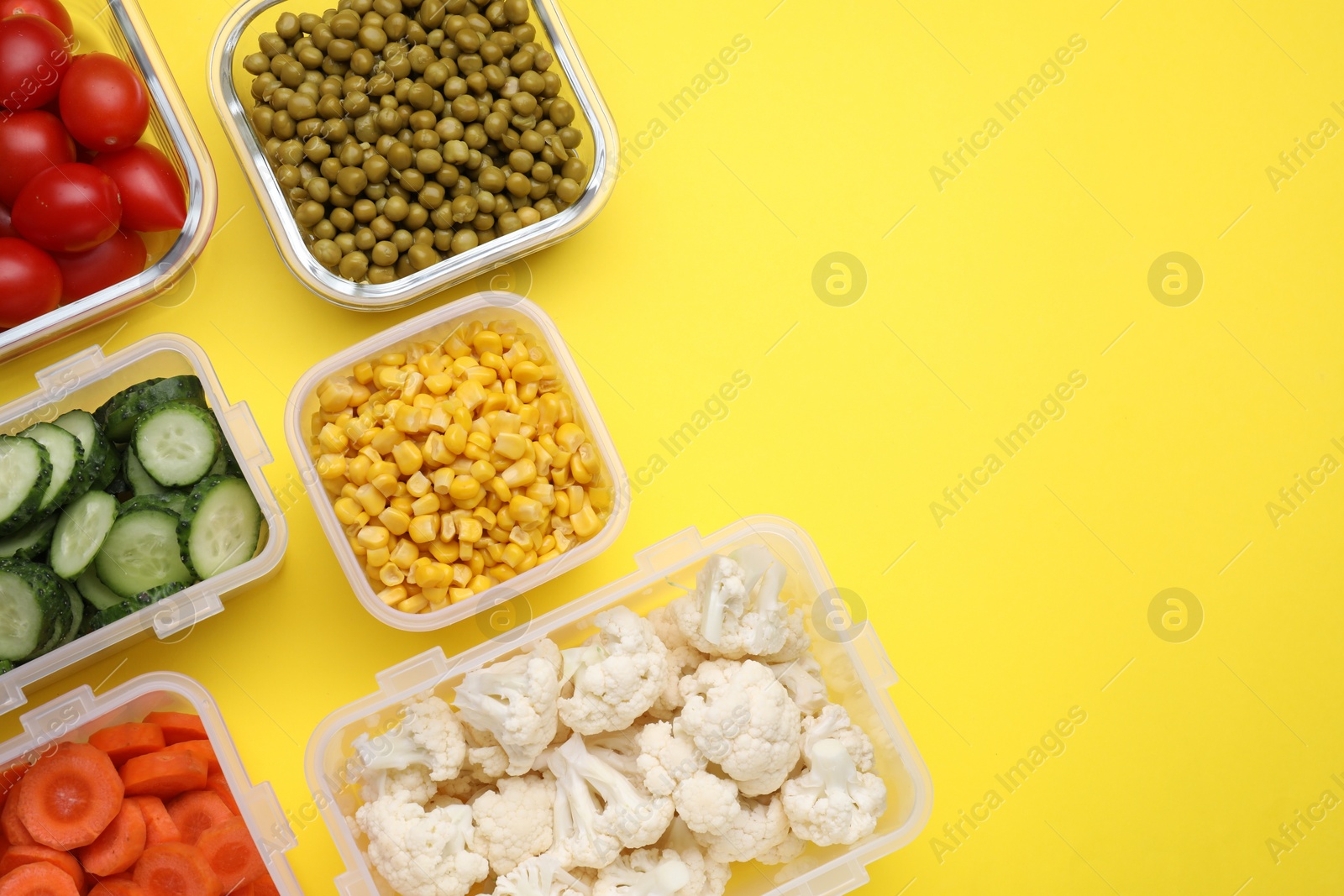 Photo of Plastic and glass containers with different fresh products on yellow background, flat lay. Space for text