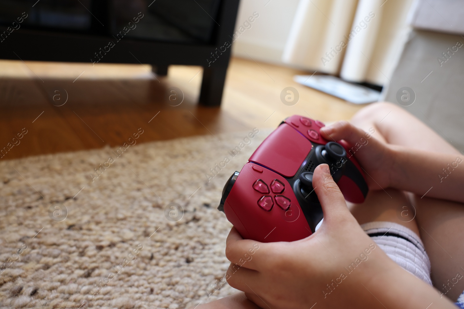 Photo of Child playing video games with controller at home, closeup. Space for text