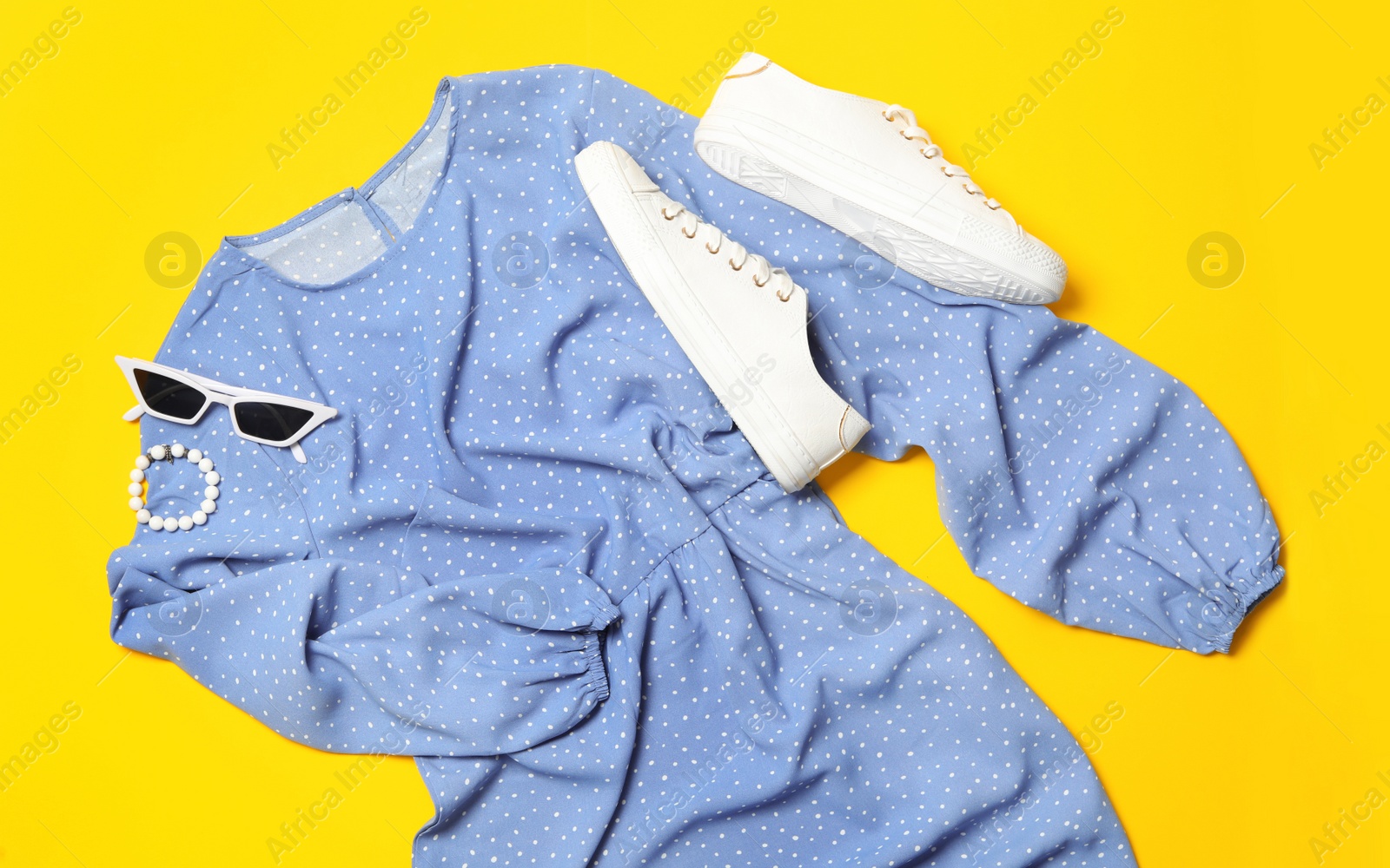 Photo of Flat lay composition with stylish blue dress on yellow background