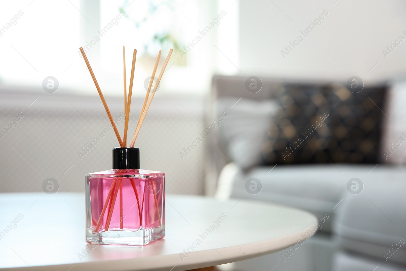 Photo of Aromatic reed air freshener on table indoors