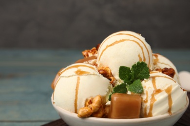 Photo of Delicious ice cream served with caramel, popcorn and sauce on table, closeup. Space for text