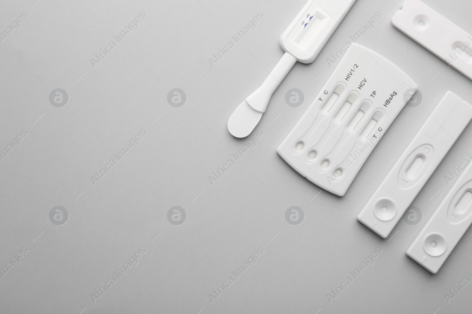 Photo of Different disposable express tests on light grey background, flat lay. Space for text