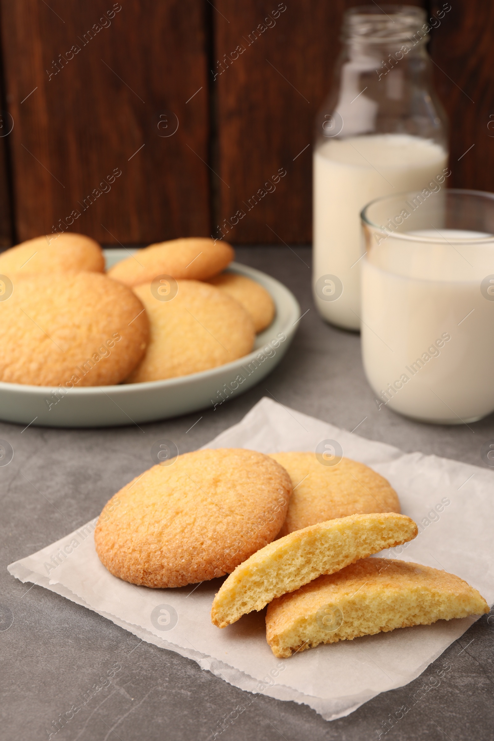 Photo of Delicious Danish butter cookies and milk on grey table, closeup