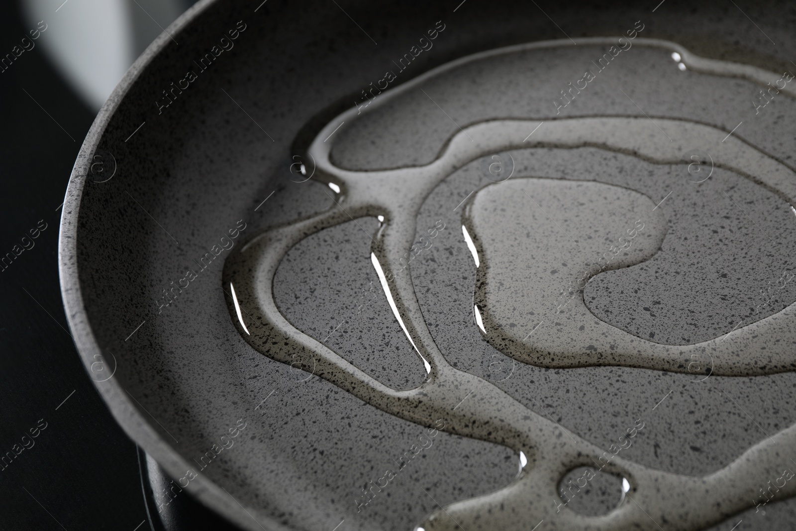 Photo of Cooking oil in frying pan on stove, closeup